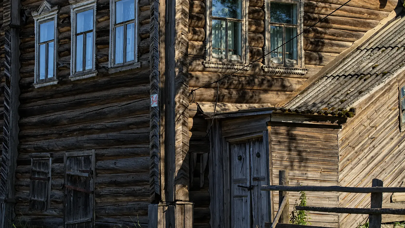 Резные окна и стены старого деревянного дома в деревне Кимжа